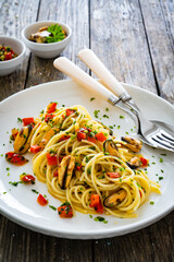 Spaghetti with mussels on wooden table
