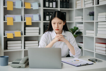 Woman who is tired and overthinking from working with tablet and laptop at modern office.