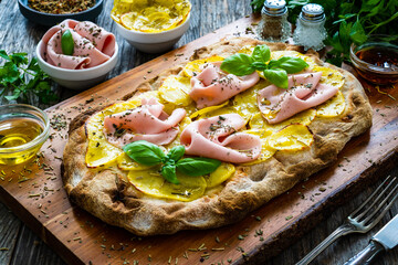 Mortadella and potato pizza on wooden table