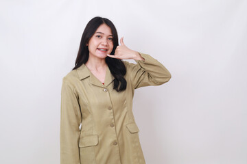 Pretty young Indonesian civil servant woman standing with calling or phone hand gesture