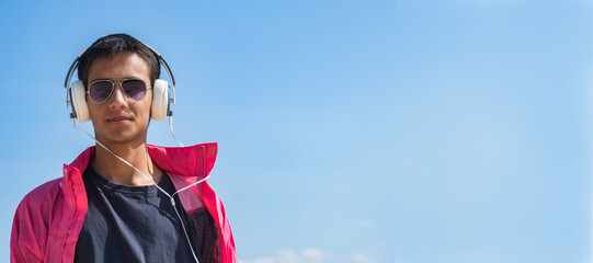 young man with headphones on blue background