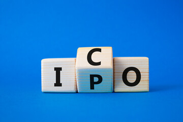 ICO and IPO symbol. Wooden cubes with words ICO - initial coin offering and IPO - initial public...