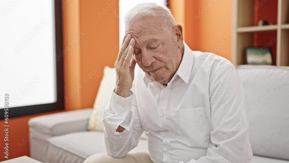 Canvas Prints Senior grey-haired man worried with hand on forehead at home