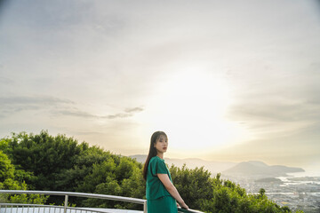 Fototapeta premium 夕陽の空と若い女性