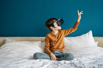 Inspired child boy experiencing virtual reality goggles immersive in futuristic world. Interested...