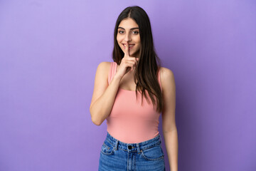 Young caucasian woman isolated on purple background showing a sign of silence gesture putting finger in mouth