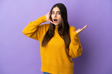 Young caucasian woman isolated on purple background making phone gesture and doubting