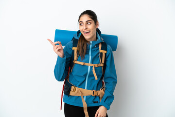 Young mountaineer man with a big backpack over isolated background intending to realizes the...