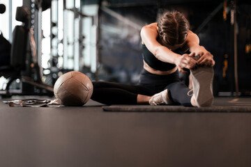 Young sporty woman stretching at the gym.