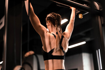 Fototapeta na wymiar Women doing pull ups training arms in the gym. Upper body training.