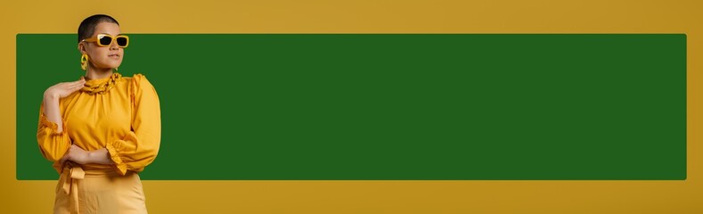 Fashionable young woman in trendy glasses looking at copy space against colorful background