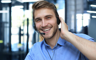 Smiling friendly handsome young male call centre operator