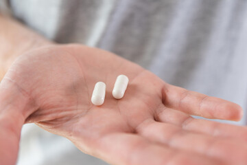 White capsules with collagen in male hand. Nutritional supplement, medicine, drug for joints protection, skin care, health care. Health support and treatment concept.