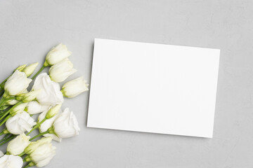 Obraz na płótnie Canvas Wedding invitation card mockup flat lay with white flowers, top view with copy space