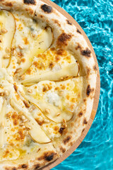 hot pizza on a wooden stand on a blue background water