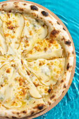 hot pizza on a wooden stand on a blue background water