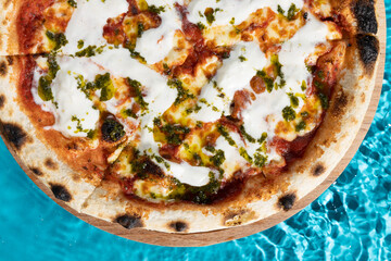 hot pizza on a wooden stand on a blue background water