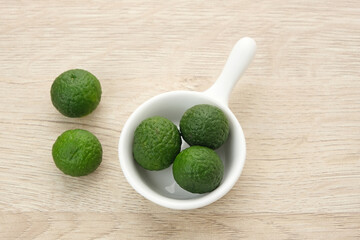 Kaffir Lime or Jeruk Limau on wooden table, food ingredient
