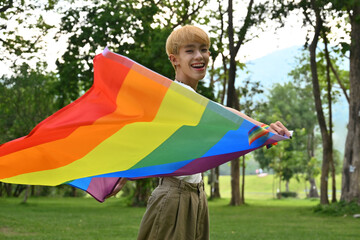 Portrait with young asian boy waving the rainbow flag, Support and celebrate the LGBT community.