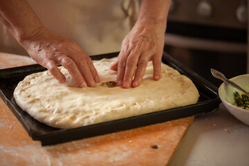 Women's hands make pasty dough