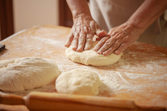 Women's hands make pasty dough