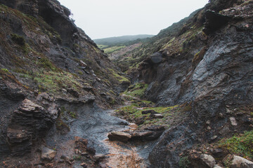 Walking through a gorge between two hills in rainy weather in the southwest of Portugal, Algarve region in March. Wandering along the Fisherman Trail
