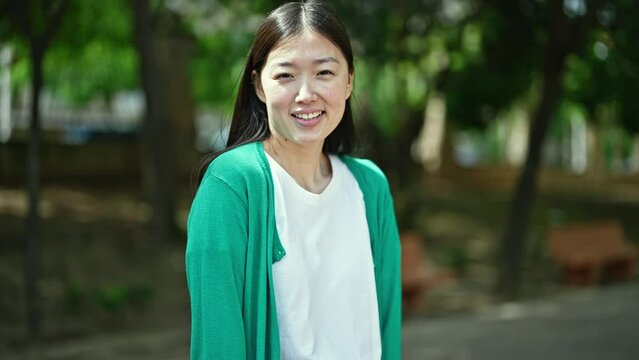 Young chinese woman smiling confident standing at park