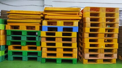 Industrial background of a pile of blue and white old pallets in warehouse