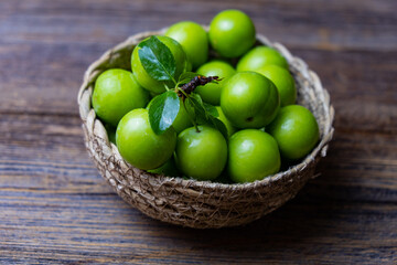 Fresh ripe organic green plum, wooden background, close-up.