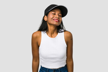 Young Indian woman cut out isolated on white background laughs and closes eyes, feels relaxed and happy.