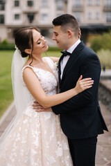 Close-up portrait of beautiful wedding couple walking outdoors. Groom and bride in the park