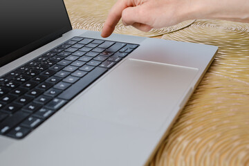 Closeup view of finger pressing enter key on laptop