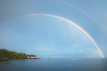Beautiful rainbow in the sky arching over fishing boats and the Firth of Forth in the quaint...