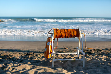 life ring with coil of rope, at the edge of the sea