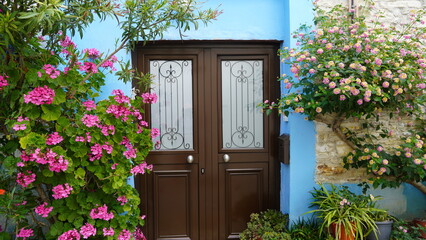 Niebieska ściana i drewniane drzwi z kwiatami balkon wejście do domu cypr - obrazy, fototapety, plakaty