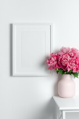 Portrait poster frame mockup on white wall, blank frame mock up with pink peony flowers