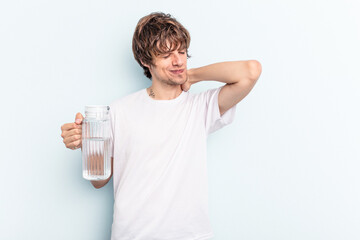 Young caucasian man holding a jar of water isolated on blue background touching back of head, thinking and making a choice.