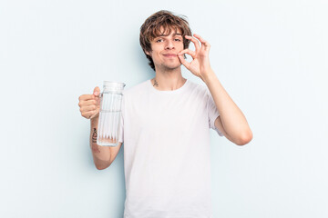Young caucasian man holding a jar of water isolated on blue background with fingers on lips keeping a secret.