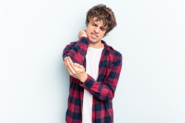 Young caucasian man isolated on blue background massaging elbow, suffering after a bad movement.
