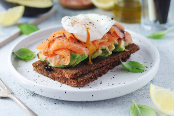 A rye bread sandwich with avocado and salmon