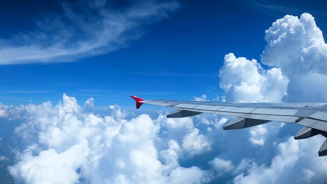 view from airline by looking out to the front and see the wings of the plane who is flying above the airspace and see many clouds With the blue sky, bright, beautiful in the concept of traveling
