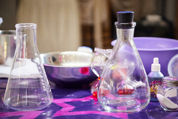 A retort, a glass jar, a phial on a table with a purple surface. Preparation for a chemical...