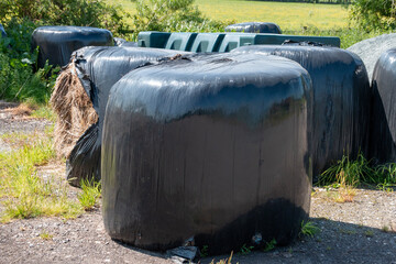 A close up view of hay bails covered in black plastic