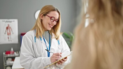 Young blonde woman doctor having medical consultation writing on document at clinic - Powered by Adobe