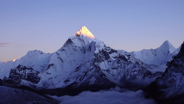 lit Peak of Ama Dablam himalaya 8000 meter mountain
 sunset with clear blue and purple sky, 2023
