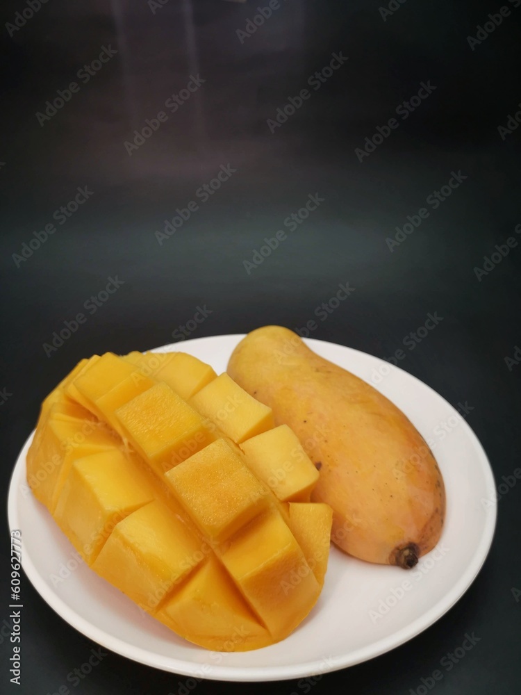 Wall mural mango tropical fruit on black background