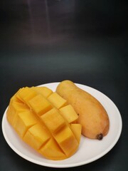 Mango tropical fruit on black background