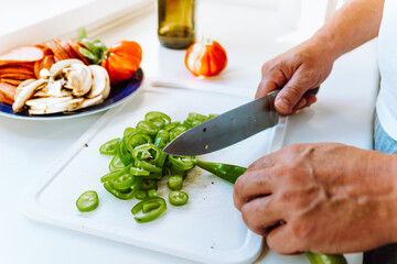 Hands man close-up top view cut pepper into slices
