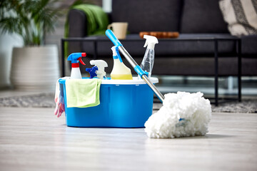 Cleaning, detergent and mop on the floor of a living room in a home for hygiene or service during...