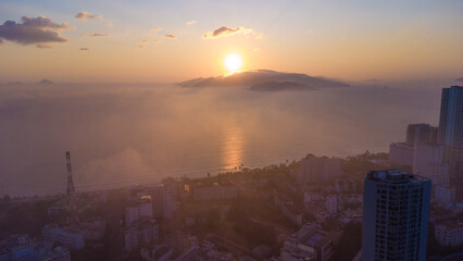 Fototapeta na wymiar fog over the city at sunrise, cityscape nha trang city in vietnam shot from drone, gorgeous asia, beach by the sea, modern city in tropics